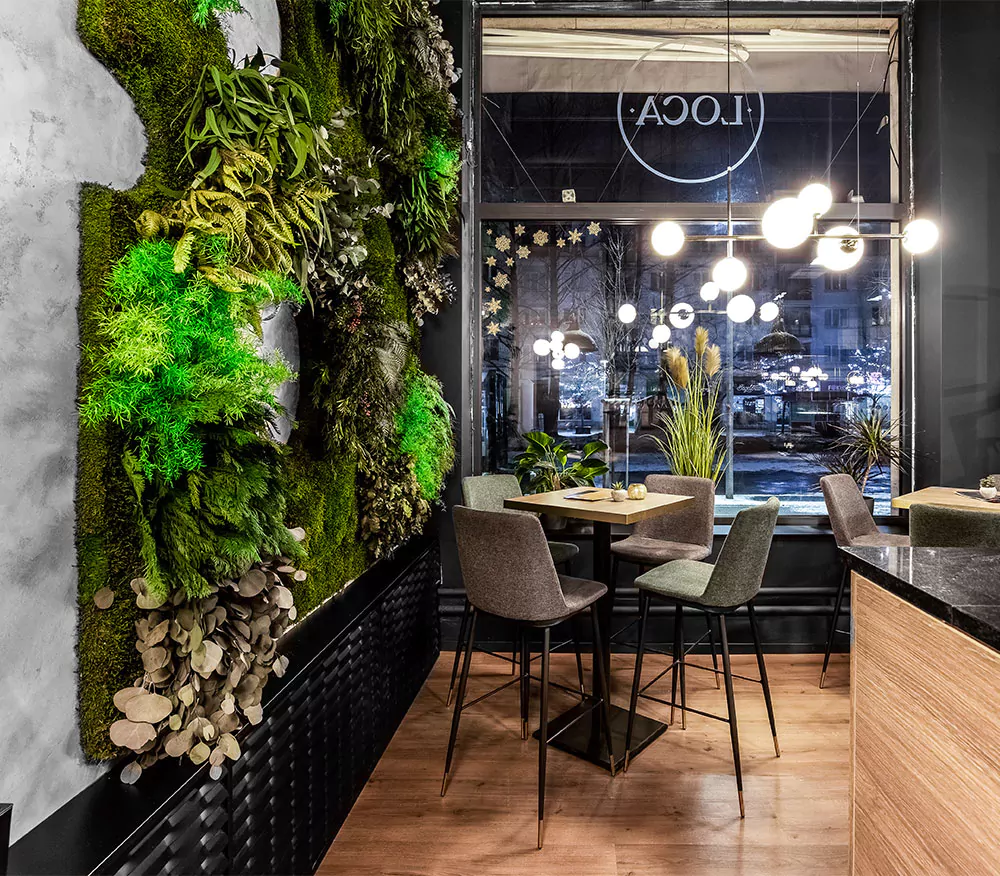 restaurace s mechovou stěnou a stolem a židlemi před ní s barem a nápisem restaurace, mechová stěna, mechové dekorace, obraz z mechu, mechová zeď, mechovy obraz, dekorativní mech