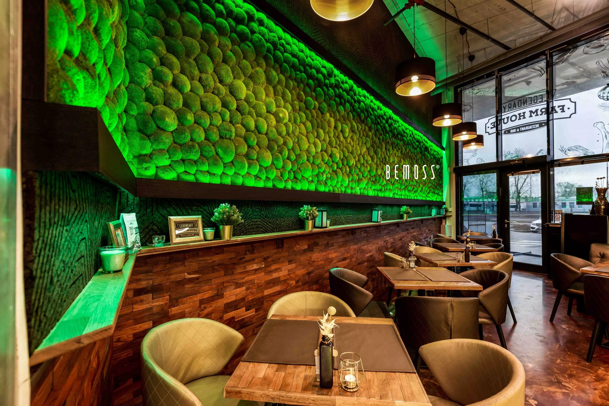 restaurace se zeleným osvětlením a dřevěnými stoly a židlemi a zelenou stěnou za pultem a zelenou stěnou za židlemi, mechová stěna, mechové dekorace, obraz z mechu, mechová zeď, mechovy obraz, dekorativní mech