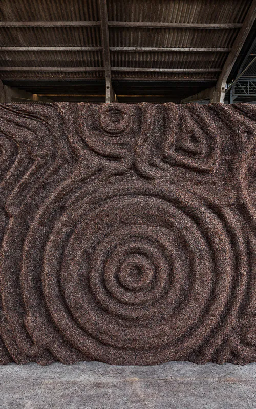 veľká kamenná socha sediaca v miestnosti vedľa okna so strechou nad ňou a radom čiernych kamenných blokov machovy obraz, stabilizovany mach, machová stena, machová dekorácia